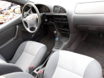Interior view of 1998 Chevrolet Metro hatchback with manual transmission and gray seats.