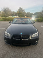 Front view of a black 2011 BMW 335IS convertible with beige leather interior and clean title for sale.