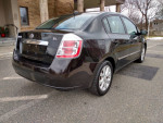 2010 Nissan Sentra SL parked with alloy wheels, automatic features, and Bluetooth connectivity for safe driving.