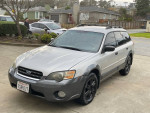 2005 Subaru Outback in silver with black wheels parked, featuring low mileage and all-wheel drive.