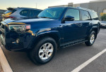 2014 Toyota 4Runner SR5 RWD in blue with 104,000 miles, parked outdoors, showcasing its sporty design.