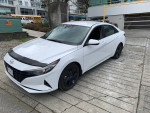 2022 Hyundai Elantra in white parked with snow tires, featuring heated seats and Apple CarPlay.