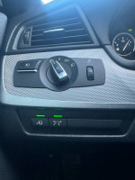 Close-up of the control panel in a 2011 BMW 535xi sedan, featuring lights and safety controls.