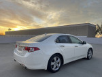 2010 Acura TSX in White Pearl parked at sunset, showing clean exterior and sleek design.