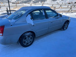 2002 Hyundai Elantra parked in snow, features manual transmission and good gas mileage.
