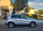 2013 Volkswagen Tiguan S 4Motion AWD parked in front of a house, showcasing its immaculate condition and stylish design.