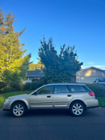 2008 Subaru Outback 2.5 XT Limited AWD parked under trees, featuring gold paint and khaki leather interior.