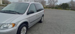 2006 Chrysler Town and Country minivan in silver color parked on an empty lot, showcasing its good condition.