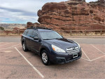 2013 Subaru Outback parked in Rocky Mountain landscape, showcasing its reliable design and adventure-ready features.