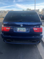 Rear view of a blue 2005 BMW X5 4.8is SUV with a license plate, parked outdoors.