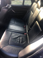 Interior view of a 2005 BMW X5 4.8is SUV showing black leather rear seats