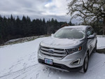 2017 Ford Edge SEL parked in snow with surrounding forest, showcasing all-wheel drive and sporty design.