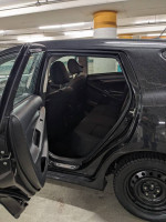 Interior view of a 2011 Toyota Matrix, showcasing rear seating and door in a parking garage.
