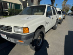 White Honda Passport parked on the street, 79,000 miles, reliable condition with minor paint fading.