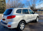 2009 Hyundai Santa Fe AWD in silver parked on a residential street, showcasing its clean design and spacious features.