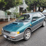 1997 Subaru Impreza Outback Sport AWD in green, parked on street with near mint condition rims, 54,000 miles