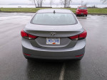 2015 Hyundai Elantra parked in a lot with winter tires, showcasing its sleek design and rear features.