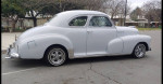 Classic 1947 Chevy Fleetmaster coupe in primer gray, showcasing its vintage design and chrome accents.