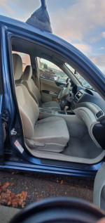 2008 Subaru Impreza interior featuring beige seats and dashboard, ideal for winter driving with AW and roof racks.