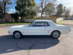 1966 Ford Mustang in Wimbledon white with red interior, showcasing excellent condition and classic styling.