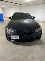 Front view of a 2018 BMW M2 F87 with 52,000 miles, parked indoors.