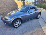 2007 Mazda MX-5 Sport in gray color, parked with top down, showcasing sleek design and features.