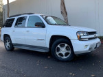 White Chevrolet TrailBlazer parked, seats seven passengers, recently serviced with clean exterior and functional leather seats.