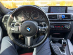 Interior view of a 2013 BMW 335i with M-Sport package, featuring a sleek dashboard and red leather seats.