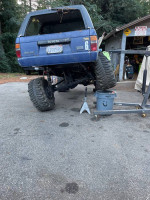 2007 Toyota 4Runner with aftermarket upgrades, elevated on jack stand in driveway