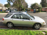 Side view of a 2003 Subaru Impreza Outback Sport with AWD, showcasing clean exterior and garage-kept condition.
