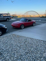 1994 Mazda MX-5 parked on the street, showcasing its sporty design and distinct features.