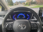 Interior view of a 2020 Toyota Corolla Hybrid with a focus on dashboard and steering wheel features