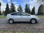2006 Toyota Prius with low mileage, parked outdoors, showcasing its clean exterior and hybrid efficiency.