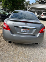 Rear view of a 2009 Nissan Maxima in good condition parked outdoors with a faded clear coat.
