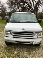 1997 Ford E-350 van in front view, low mileage, ready for new adventures with minor cosmetic issues.