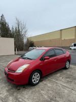 2007 Toyota Prius in red color, clean exterior, parked on pavement, ideal for economical driving and road trips.