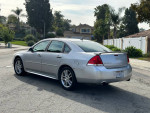 2013 Chevrolet Impala LTZ FWD in silver, clean condition, parked on the street with palm trees in background.