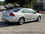 2013 Chevrolet Impala LTZ in silver parked, showcasing sleek design and alloy wheels, ideal for reliable driving.
