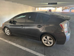 2010 Toyota Prius in gray parked indoors, featuring tinted windows and a fuel-efficient design.