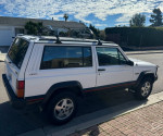 1993 Jeep Cherokee Country parked on street, showcasing its classic design and roof rack features.