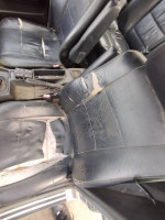 Worn black leather seats in a 1989 BMW 535i, showing signs of aging and damage.
