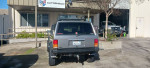 Rear view of a gray 1993 Jeep Cherokee with a cargo rack parked outside Autosheild.