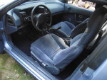 Interior view of a 1987 Nissan Pulsar NX featuring blue fabric seats and modern dashboard layout.