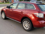 Red 2012 Mazda CX-7 parked on street, showing rear side and alloy wheels with a clean appearance.
