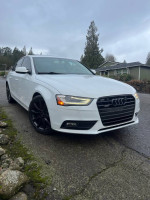 2013 Audi A4 2.0T Premium FWD parked on a road under cloudy skies, featuring sleek design and a sporty look.