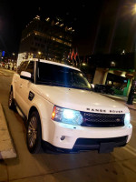 2012 Land Rover Range Rover Sport HSE parked at night, showcasing its sleek design and headlights