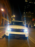 Front view of a 2012 Land Rover Range Rover HSE parked at night in a city setting.