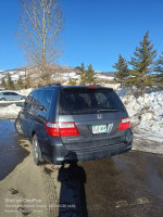 2000 Honda Odyssey minivan parked in snowy area, well maintained, ready for camping trips.