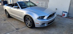 2014 Ford Mustang Convertible in silver with GT wheels, clean title and 69K miles, parked outdoors.