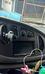 Interior view of a 2007 Ford E-250 cargo van featuring a touchscreen and controls, ideal for work use.